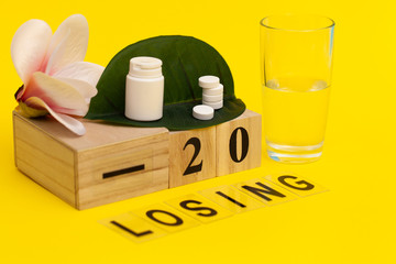 Pills for weight loss on a yellow background