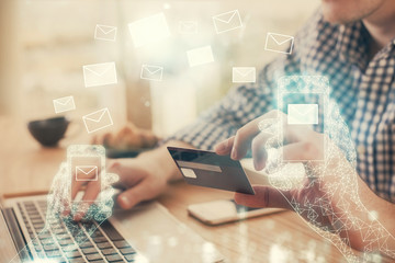 Double exposure of man hands holding a credit card and envelop fly drawing. E-mail and E-commerce pay on-line concept.
