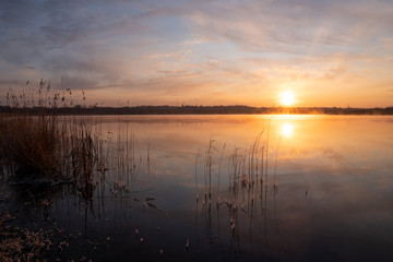 Naklejka na ściany i meble Gorgeous sunrise over the lake with reflection of the sun on the lake and spring