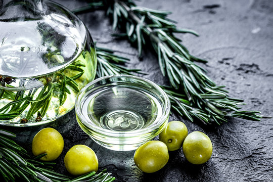 oil in carafe with spices and olive on stone background