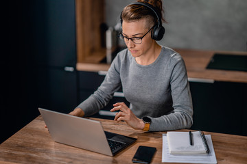 Woman wearing headphones and watching a webinar