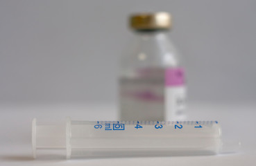 Close up of syringe, on background vial of  antibiotics, injection drugs used in treatment of ...