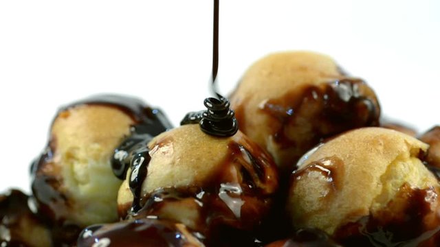 Dolly Slide shoot of pouring Chocolate sauce over profiteroles