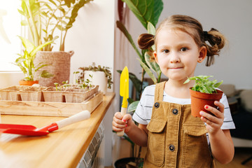 Five year old girl posing for a photo with a pot and gardening shovel in hands © zzzdim