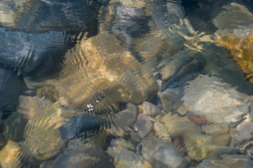 pebble stones on the sea beach, the rolling waves of the sea with foam