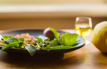 Fresh ingredients for preparing Italian pesto sauce - lemon basil sprigs, peeled seeds of cedar nuts, large garlic clove, Greek olive oil, Parmesan cheese
