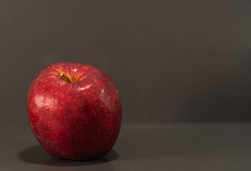 Fruits of macã (Malus domestica) in natura on dark and mirrored background