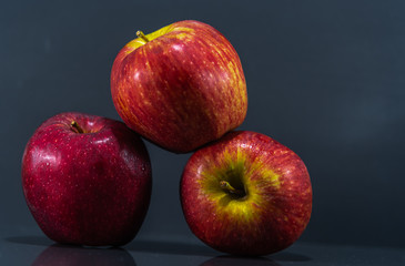 Fruits of macã (Malus domestica) in natura on dark and mirrored background