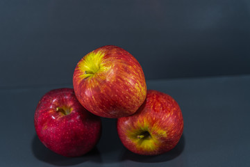Fruits of macã (Malus domestica) in natura on dark and mirrored background