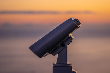 Binoculars for tourists on the background of the sunset