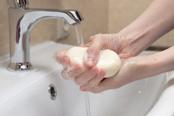 Hygiene. Cleaning Hands. Washing hands with soap. Woman's hand with white soap and foam. Protect yourself from coronavirus COVID-19 pandemia.