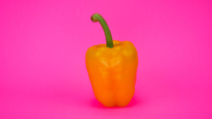 Un piment jaune sur un arrière plan rose fluorescent 