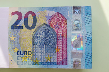 A bundle of Euro banknotes and coins on a light background