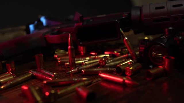 Ammunition dropping in front of blacked out AR-15 Riffle in slow motion 120fps.