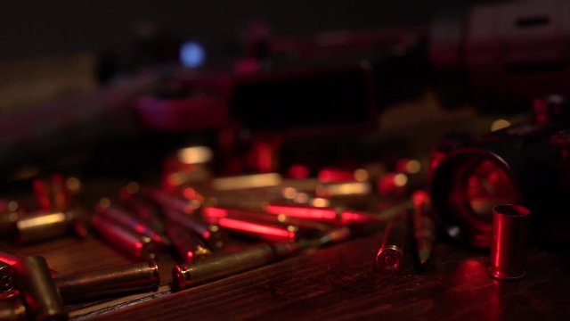 Man picks up AR15 ammo from workbench with hands.