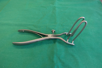 on  green surgical drape lies a surgical anal dilator