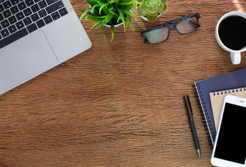 Workplace at home with wood table. Top view from above of laptop with notebook and coffee. Office space for modern creative work of designer. Flat lay with blank copy space. Business-finance concept.