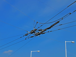 electrical powerful high voltage wire cables heap for transport (urban electrical traffic as trolleybus) on blue sky with white clouds