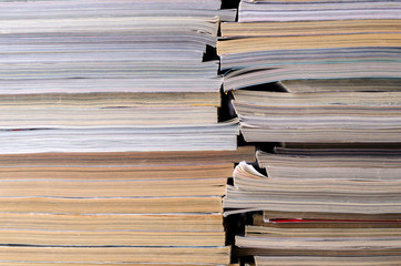 Closeup background of a pile of magazines.