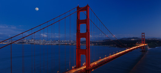 Obraz premium Panorama of Golden Gate Bridge and San Francisco skyline at twilight with rising moon