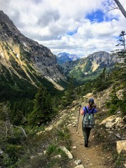 Hiking the rocky terrain of the Crypt Lake Trail, a steep ascent to Crypt Lake including walking a long the very edge of a mountain.  The hike is in Waterton Lakes National Park in Alberta, Canada