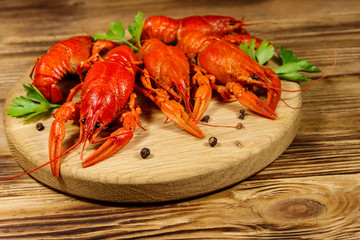 Boiled crayfish on cutting board on wooden table