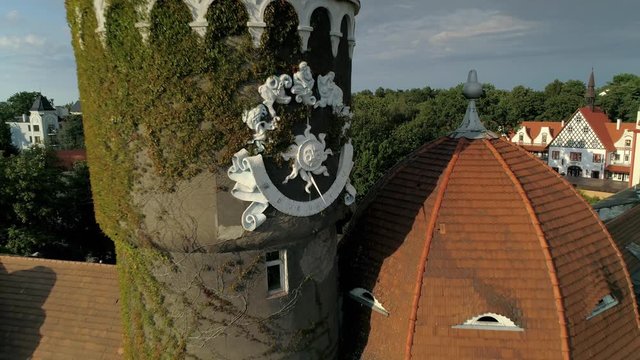 Zelenogradsk german style cityscape. Funny house sundial on tower roof with eyes. Unique attraction Kaliningrad region Russia. Historic street. Travel tourism. Summer sunny horizon. Aerial flying back