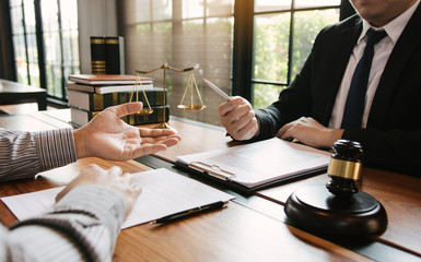 Legal advisor is explaining the offense under the law in the book at office.