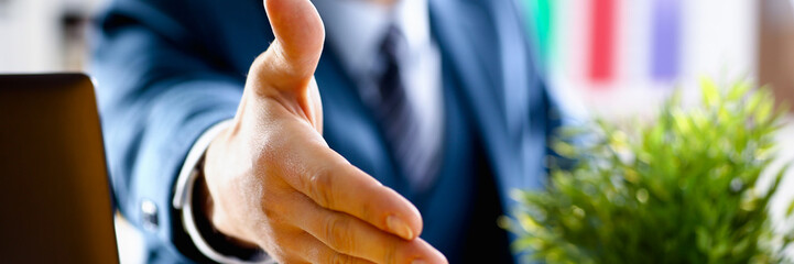 Man in suit and tie give hand as hello in office closeup. Friend welcome mediation offer positive introduction thanks gesture summit participate approval motivation male arm strike bargain