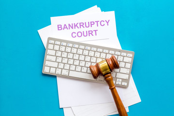 Bankruptcy court concept with gavel, document, keyboard on blue background top-down