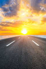 Naklejka premium Asphalt highway road and sky sunset clouds landscape.