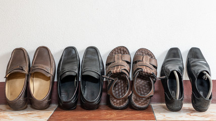 Many pairs of shoes in many colors placed in front of the room, white walls