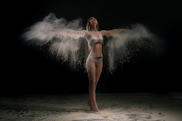 Young woman in white dust cloud shot