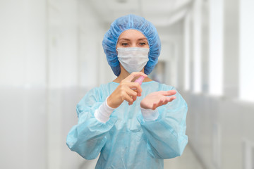 Fototapeta premium Female doctor treats hands with antiseptic gel.