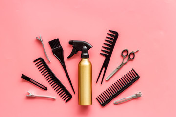 Professional hairdressing set with combs, spray and sciccors on pink background top-down