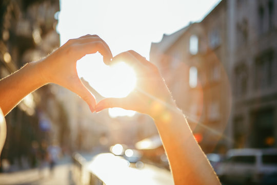 woman hands in heart love shape symbol sunset