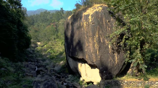 A huge rock shaped like an apple , called "Apple Stone", with an waterfall passing through the famous rock. Footage shot at Jhalong, Dooars, West Bengal - India.