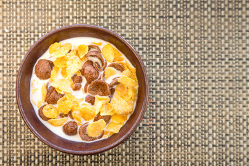 Bowl of crunchy cereal crop with milk is served on table, the most easy-delicious breakfast for children with fully nutrients. Food close-up and selective focus photo.