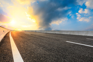 Asphalt highway road and sky sunset clouds landscape.