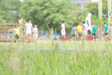 Obraz premium Abstract blurry shot of people relaxing by playing football or soccer at the stadium.
