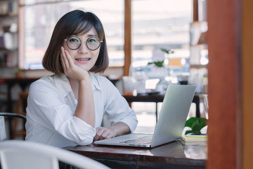 Fototapeta premium Beautiful Asian businesswoman working with laptop computer at a coffee shop