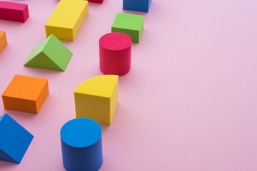 Set of colorful geometric cube or block toy on pink background with copy space. Abstract pattern design composition by shape and form. Education, business solution and creative design product concept.