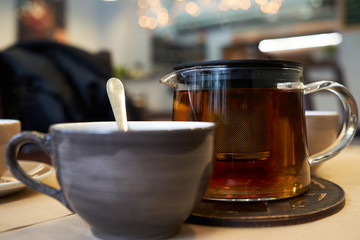 Cup and teapot on a table in a cafe.