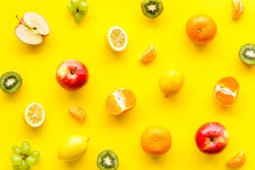 Colorful fruit pattern. Cut apple, kiwi, citrus on yellow background top-down