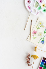 Watercolor painting. Picture with flowers, paints, palette on white background top-down copy space