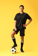 Young African-American football player on color background