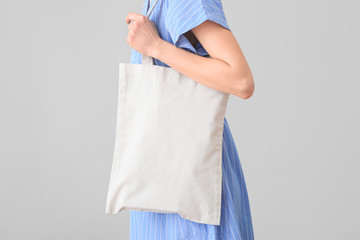 Woman with eco bag on light background