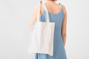 Woman with eco bag on light background