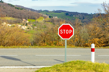 Stop sign on a background of rural landscape in France.