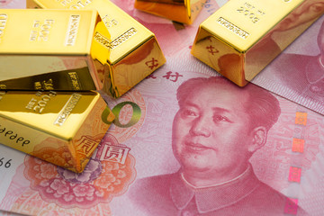 Gold bars on Chinese yuan bill banknotes background. Concept of gold future trading, online asset...